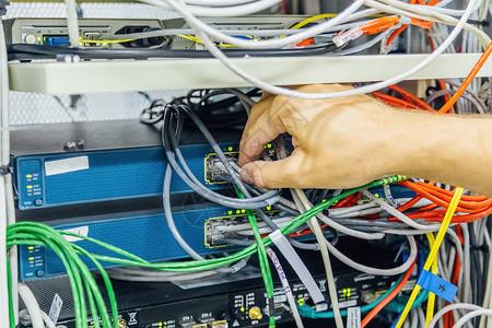 工程师将网络电缆连接到服务器机房数字通信光纤枢图片